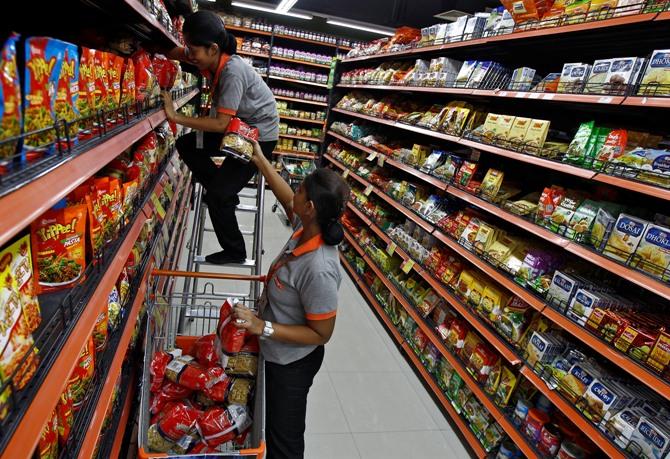 A worker stacks food packets inside a retail outlet at a shopping mall in Kolkata 