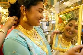 This file photographs shows a woman trying gold ornaments on the occasion of the Hindu festival of Dhanteras in Kolkata.