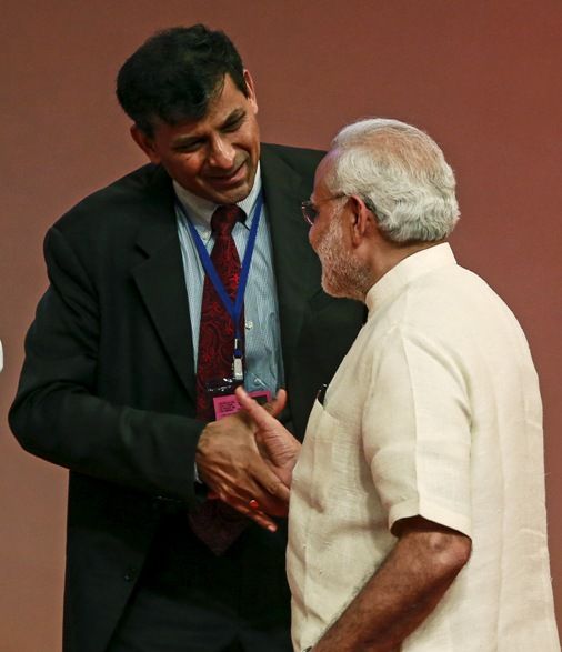 Prime Minister Narendra Modi (R) shakes hand with Reserve Bank of India (RBI) Governor Raghuram Rajan at an event on financial inclusion in Mumbai April 2, 2015. 