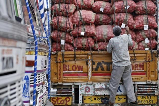 A labourer prepares to unload sacks of potatoes from a truck at a wholesale vegetable and fruit market in New Delhi.