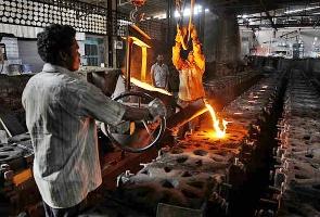 Workers tend to a furnace at a steel factory. 