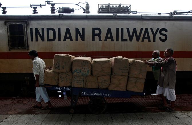 Porters transport goods on a hand-pulled trolley to load onto a train at a railway station in Kolkata. 