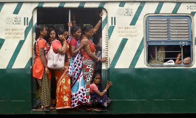 Commuters stand at an open doorway of a suburban train during the morning rush hour in Kolkata. Rupak De Chowdhuri/Reuters