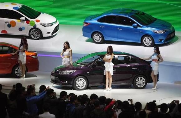 Models pose by Toyota cars during the 15th Shanghai International Automobile Industry Exhibition in Shanghai.