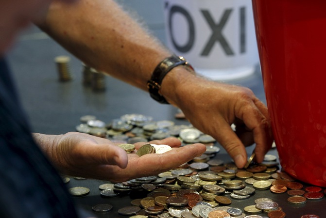Donations of cash are counted following a collection for the Greek Solidarity Campaign, during a rally in support of Greece at the TUC's Congress House, in London, Britain, July 6, 2015.