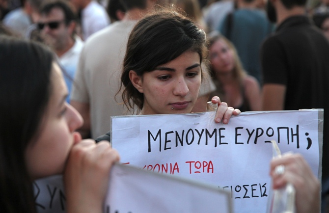Youths hold a placard that reads 'Do we stay in Euro?' during an anti-austerity protest in central Athens, Greece, July 12, 2015.