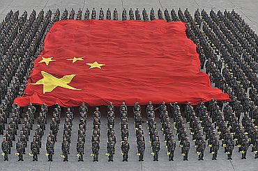 Paramilitary policemen hold a Chinese national flag during a parade training session in Beijing