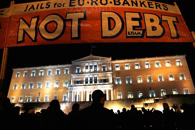 People are silhouetted in front of the parliament during an anti-austerity pro-government demonstration in Athens February 16, 2015. Greece and its creditors made little progress in recent days toward an interim funding deal, officials involved in the talks said, citing wide differences over how the Athens government can deliver on election promises and satisfy lenders.