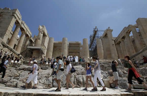 Tourists make their way in front of the Propylaia at the archaeological site of the Acropolis hill in Athens.