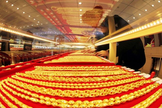 A sales assistant arranges gold necklaces at a store in Lianyungang, Jiangsu province.