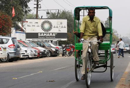Image: A man pedals his rickshaw past Sahara India Complex building in Noida on the outskirts of New Delhi. Adnan Abidi/Files/Reuters