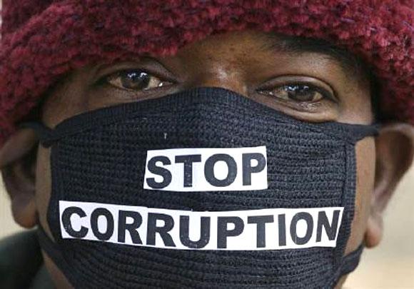 Image: An employee of telecom operator systems, displays an Indian currency note as he takes part in a silent protest against the telecom corruption scandal. Photographs: Parivartan Sharma/Reuters.