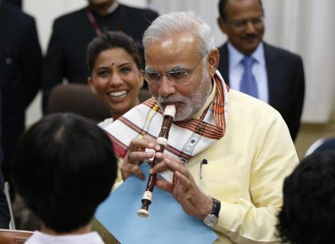 Image: Prime Minister Narendra Modi tries to play a soprano recorder before school children at Taimei Elementary School in Tokyo. Photograph: Issei Kato /Reuters