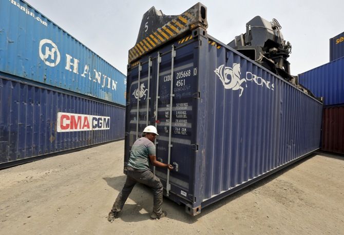 Image: A worker closes the door of a container as it is stacked at Thar Dry Port in Sanand, Gujarat, April 21, 2015. Photograph: Amit Dave/Reuters