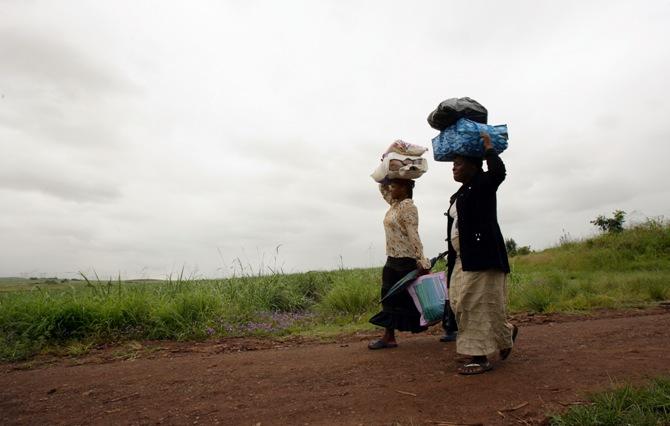 Guardians of orphans begin their long journey home after collecting food distributed by church workers at the Holy Cross Hospice near Emoyeni, in South Africa's KwaZulu Natal province.