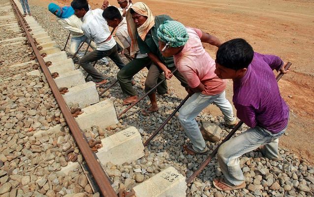 Labourers work at the installation site of a new railway track on the outskirts of Agartala, capital of India's northeastern state of Tripura