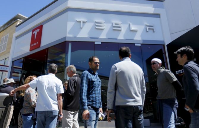 People wait in line at a Tesla Motors dealership to place deposits on the electric car company’s mid-priced Model 3 in La Jolla, California