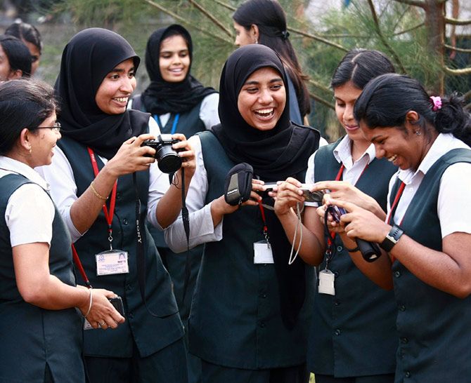 IMAGE: Students from the Federal Institute of Science and Technology (FISAT) laugh while reviewing their portraits before participating in a competition on self-portrait photographs at the college campus in Angamaly, Kochi. 