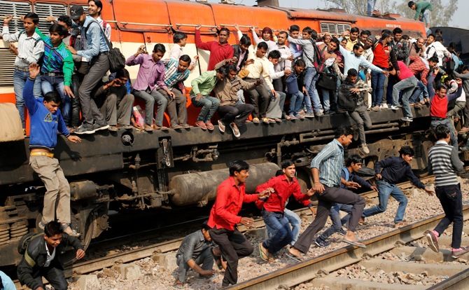 Passengers jump from an overcrowded train. 