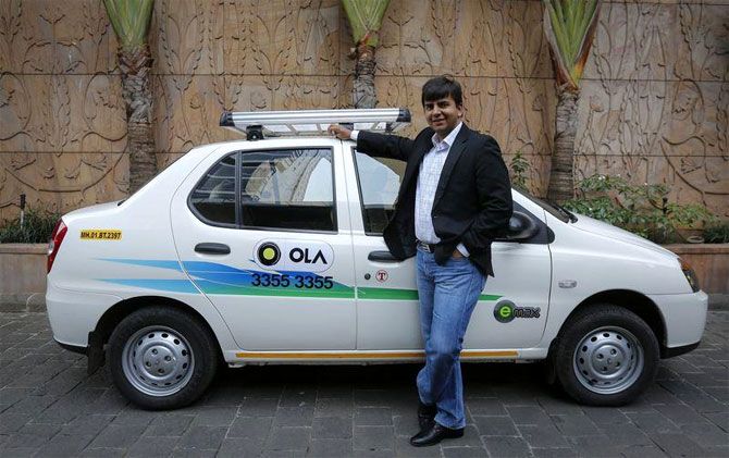 Bhavish Aggarwal, CEO and co-founder of Ola, an app-based cab service provider, poses in front of an Ola cab in Mumbai March 3, 2015. Reuters/Shailesh Andrade