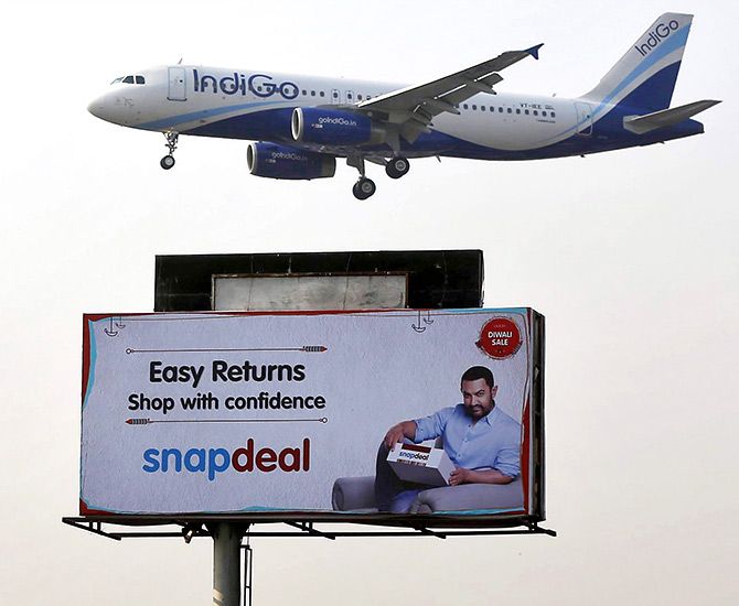 An IndiGo Airlines aircraft flies above an advertisement of Indian online marketplace Snapdeal featuring Bollywood actor Aamir Khan, in Mumbai, India, October 16, 2015. Photo: Shailesh Andrade/Reuters 