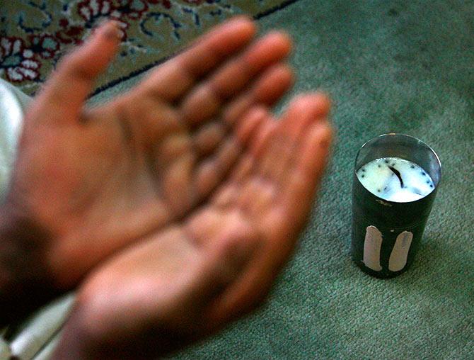 A Kashmiri Muslim man prays in front of a glass of traditional drink called Sharbat, made of a mixture of milk, almond and coconut before breaking his day-long fast during Ramadan inside the shrine of a Sufi saint in Srinagar August 24, 2009. Muslims around the world abstain from eating, drinking and sexual relations from sunrise to sunset during Ramadan, the holiest month in the Islamic calendar. Fayaz Kabli/REUTERS 