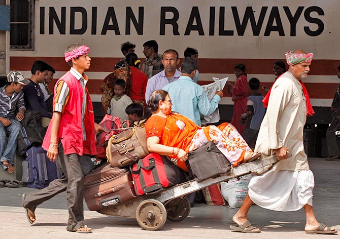 Porters transport a passenger and her luggage on a hand-pulled cart at a railway station in Kolkata February 25, 2011. Photo: Rupak De Chowdhuri/Reuters 