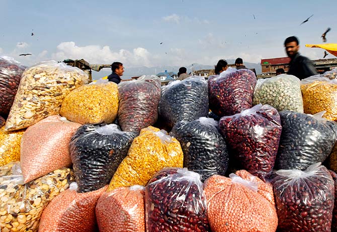 Men walk behind plastic bags containing pulses for sale at a market in Srinagar March 9, 2012. Photo: Fayaz Kabli /Reuters