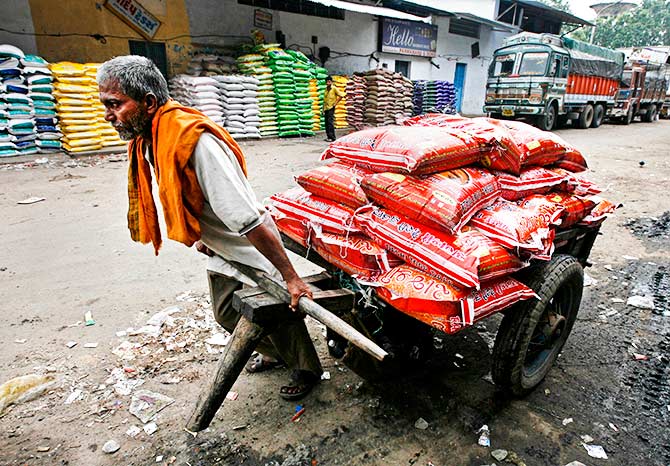 A labourer pulls a handcart loaded with sacks of pulses at a wholesale food market in the western Indian city of Ahmedabad August 13, 2010. Photo: Amit Dave/Reuters