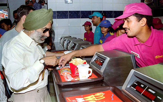 An Indian buys food from the first outlet in India of US fast food giant Mcdonald's in New Delhi, October 13, 1996. Photo: Stringer/Reuters