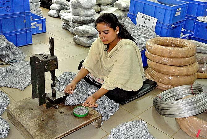 A woman makes a chain mail in the workshop 