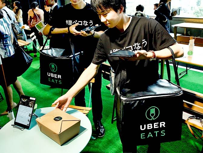 Staff deliver lunch boxes as they demonstrate a food-delivery service at the launching event of UberEats in Tokyo, Japan, September 28, 2016. Photo: Kim Kyung-Hoon/Reuters