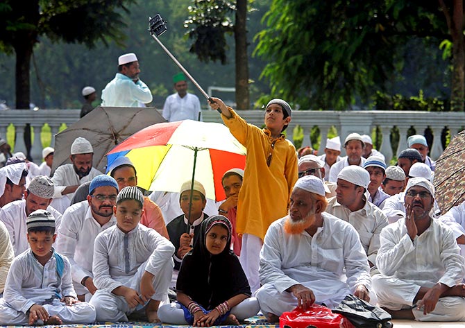 A boy uses a selfie stick to take a photograph before offering Eid al-Adha prayers on a road in Kolkata, India September 13, 2016. Photo: Rupak De Chowdhuri/Reuters