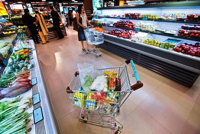 A trolley laden with fresh and processed food sits parked in an aisle as customers shop at a supermarket in Mumbai May 30, 2011. Photo: Vivek Prakash/Reuters