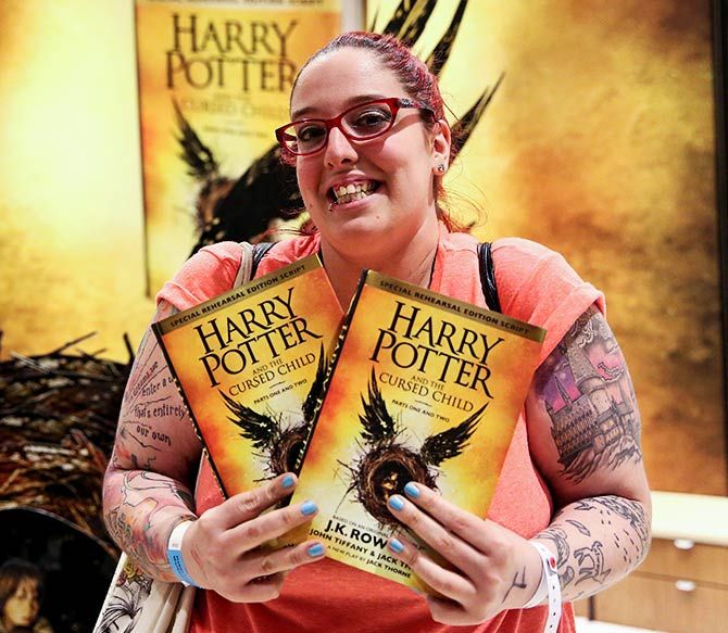 A woman holds copies of Harry Potter and the Cursed Child, parts one and two at a bookstore in London, Britain July 31, 2016. Photo: Neil Hall/Reuters