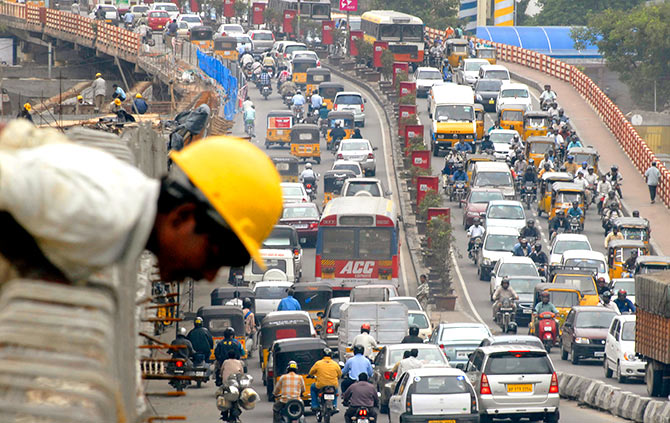 A worker leans on the wall of a flyover as traffic comes to a standstill on a busy road in the southern Indian city of Hyderabad June 27, 2007. Photo: Krishnendu Halder/Reuters