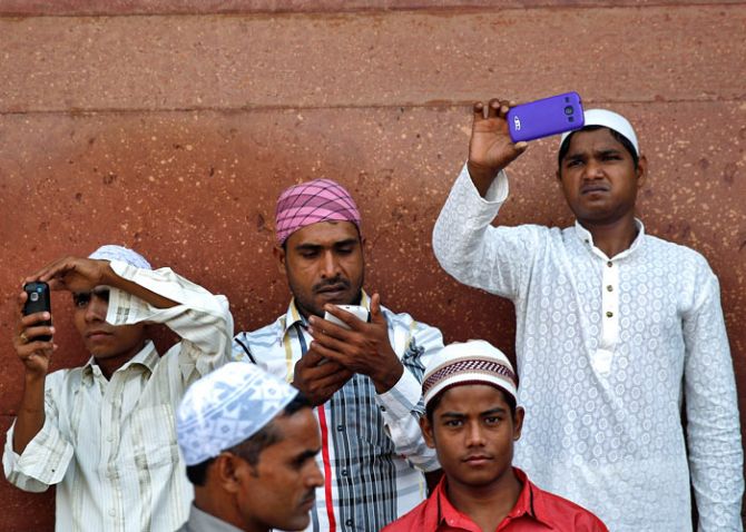 Muslims use their mobile phones after offering Eid al-Adha prayers at the Jama Masjid (Grand Mosque) in the old quarters of Delhi October 6, 2014. Ahmad Masood/Reuters