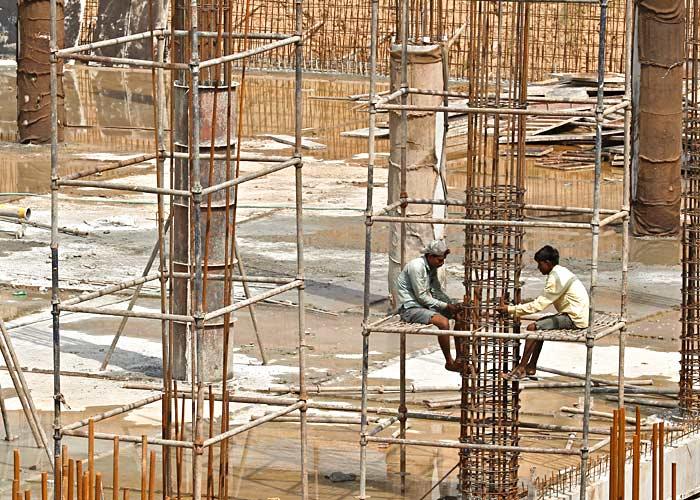 Labourers work at the construction site of a multi-level parking in Chandigarh July 10, 2014. Photo: Ajay Verma/Reuters