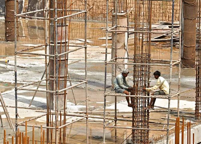 Labourers work at the construction site of a multi-level parking in Chandigarh July 10, 2014. Photo: Ajay Verma/Reuters