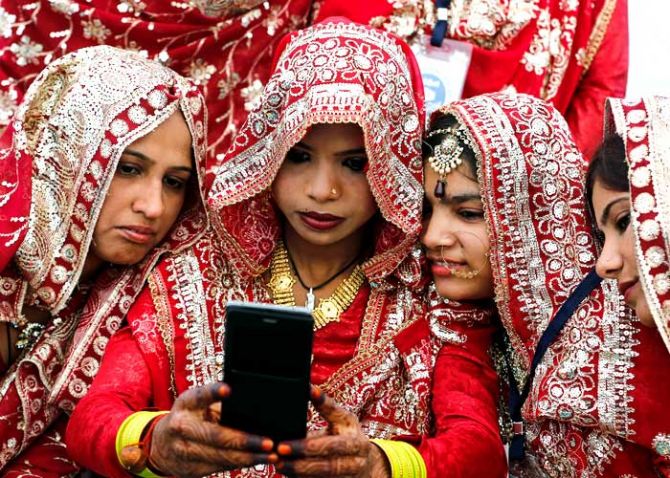 Muslim brides pose for a selfie as they wait for the start of a mass marriage ceremony in Ahmedabad, India, February 7, 2016. Amit Dave/Reuters