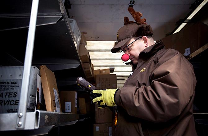 A delivery man with Chruistmas deliveries. Photograph: Carlo Allegri/Reuters.  