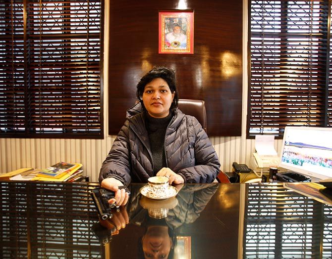 Nalini Bharatwaj, 37, chairman of a management institute, holds a gun she keeps for security, while posing in her office in New Delhi. Photograph: Mansi Thapliyal/Reuters.