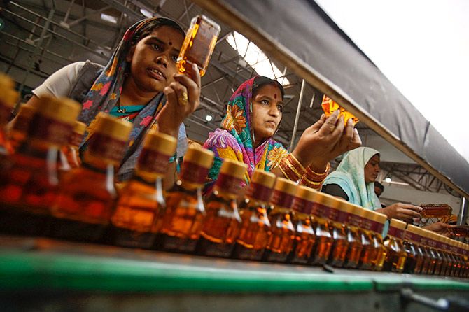 Bottling plant workers check bottles of Black Power whisky for impurities at a Tilaknagar Industries distillery and bottling unit in Shrirampur, about 300 km northwest of Mumbai. Photograph: Vivek Prakash/Reuters.