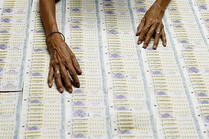 A vendor arranges lottery tickets for sale as she waits for customers at her shop in Bangkok's suburbs, Thailand May 26, 2017. Photographt Chaiwat Subprasom/Reuters.