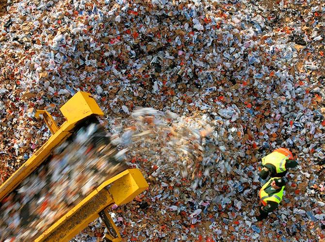 Two customs officer of the harbour customs authority check the shredding of counterfeit Nike, Adidas and Puma trainers at the Hamburg harbour November 14, 2006. Photo: Christian Charisius/Reuters