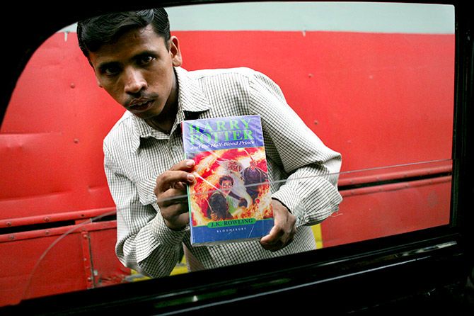 An Indian street hawker sells a pirated copy of the book "Harry Potter and Half-Blood Prince" for 250 rupees ($6), at a busy traffic intersection in Bombay, August 3, 2005. Photograph: Arko Datta/Reuters