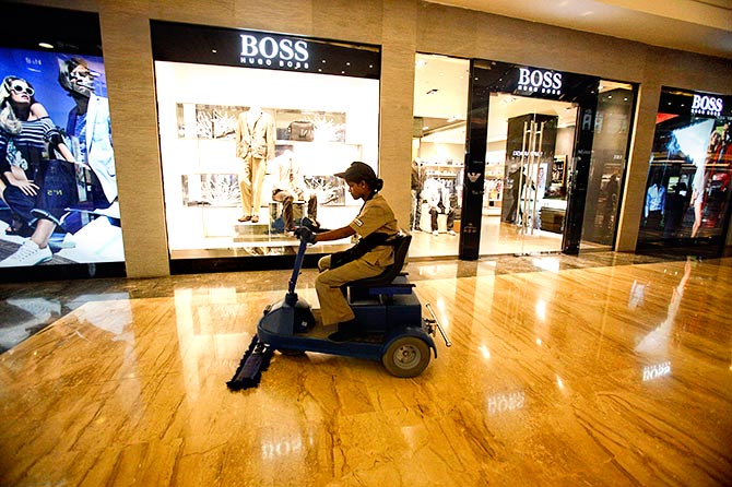 An employee operates a floor cleaning machine in a Mumbai mall. Photograph: Vivek Prakash/Reuters