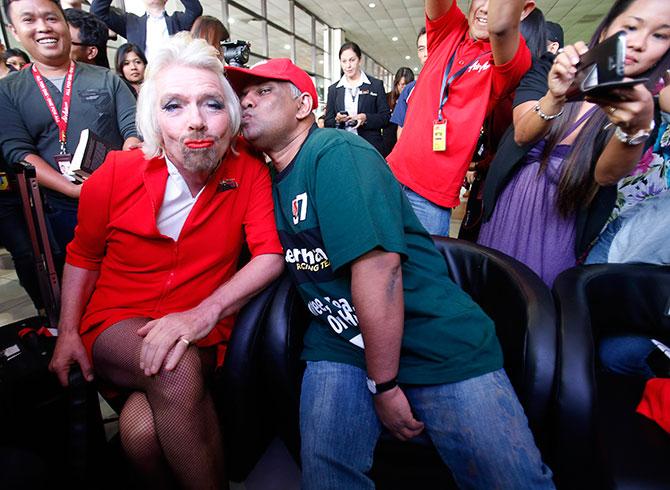 AirAsia's Chief Executive Tony Fernandes pretends to kiss British entrepreneur Richard Branson, left, who wears an AirAsia stewardess uniform, during an AirAsia promotional event in Sepang, outside Kuala Lumpur. Photograph: Bazuki Muhammad/Reuters 