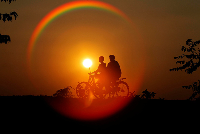 Boys are silhouetted against the setting sun as they ride bicycles on the outskirts of Agartala, Tripura. Photograph: Jayanta Dey/Reuters