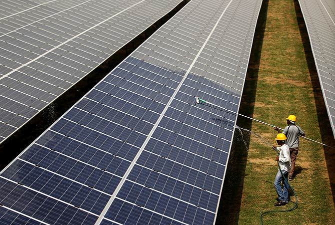 Workers clean photovoltaic panels inside a solar power plant in Gujarat, India, in this July 2, 2015. Photograph: Amit Dave/Reuters.